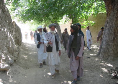 Eine Gruppe von Männern mit Turban geht einen Pfad entlang.