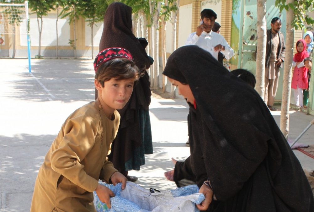 A boy and a woman carry a bag of food.